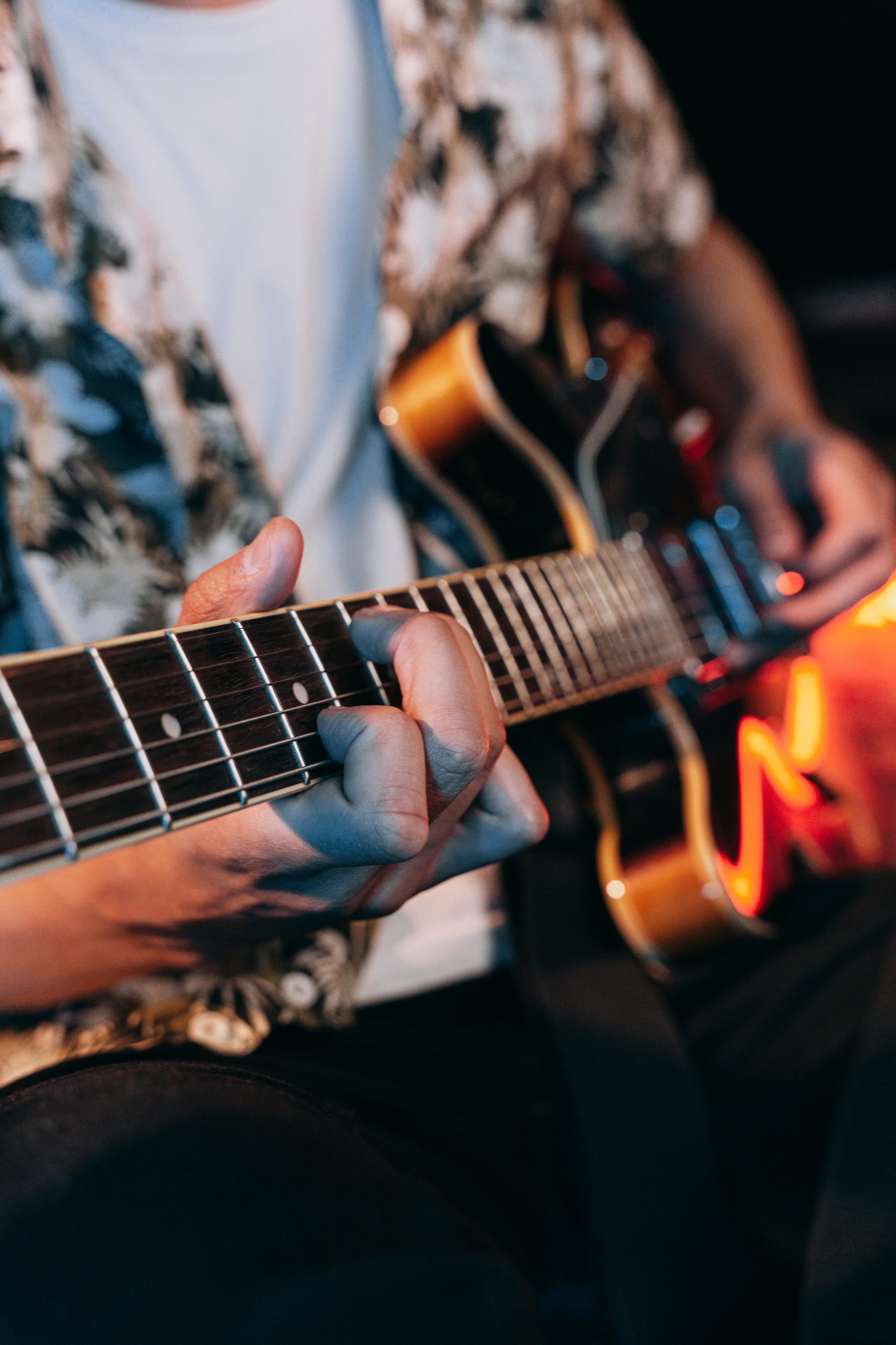 Plan rapproché sur un jeune homme jouant de la guitare électrique 